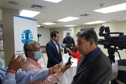Iván Prieto (derecha) y Miguel Palacios (centro, al fondo), directivos de la Asociación de Laboratorios Farmacéuticos del Ecuador (ALFE), en  la rueda de prensa de este martes 22 de marzo de 2022.