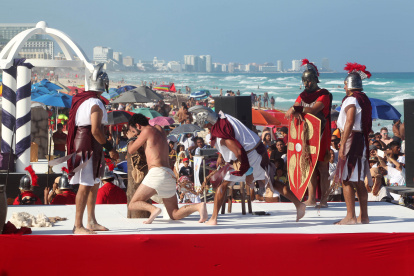 Fieles representan el viacrucis durante la celebración del Viernes Santo en una playa de Cancún (México).
