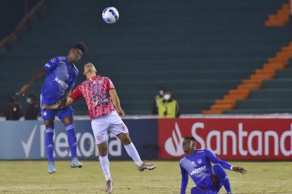 Robin Ramírez (c) de Independiente disputa el balón con Jackson Rodríguez de Emelec.