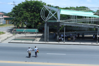 Peatón. Dos mujeres cruzan casi corriendo la vía, ante el deterioro del paso peatonal del sector donde ocurrió un accidente.