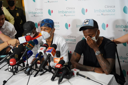 Fotografía cedida hoy por la Alcaldía de Cali que muestra al médico Laureano Quintero (c), director médico de la clínica Imbanaco de Cali, mientras anuncia a los medios de comunicación la muerte del exfutbolista colombiano Fredy Rincón en compañía de sus hijos