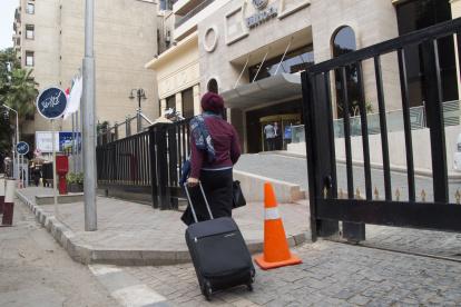 - Mujer egipcia con su maleta pasa ante un hotel en el barrio de Zamalek en El Cairo (Egipto). Pese a que ninguna ley exige que una mujer tenga que ir acompañada por un hombre para poder alojarse en un hotel, hay establecimientos de distintos puntos de Egipto, principalmente los hoteles de baja categoría, que exigen a las mujeres ir acompañadas de un familiar varón para reservar una habitación. EFE/ Pablo Pérez