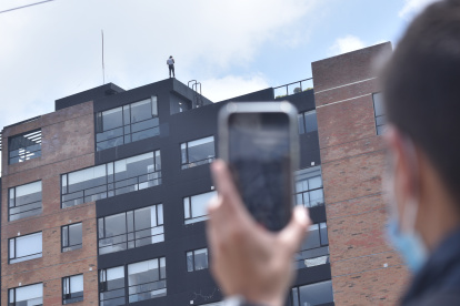 Muchas personas grababan al hombre mientras estaba parado en el borde de la terraza.