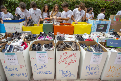 Miembros de "Loving Soles", un proyecto de jóvenes que recolecta zapatos para compartir con personas necesitadas, fueron regitrados al clasificar las donaciones, en Miami Lakes (Florida, EE.UU.).