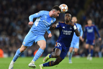 Aymeric Laporte, del City, disputa el balón con el madridista Vinicius Junior.