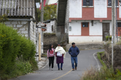 Un grupo de personas camina por una calle vacía, el 9 de abril de 2022, en Ambatillo (Ecuador)
