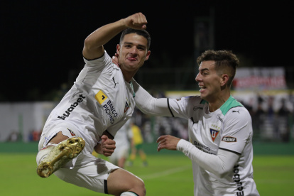 Alexander Alvarado (i) de LDU celebra un gol en un partido de la Copa Sudamericana ante Defensa y Justicia.