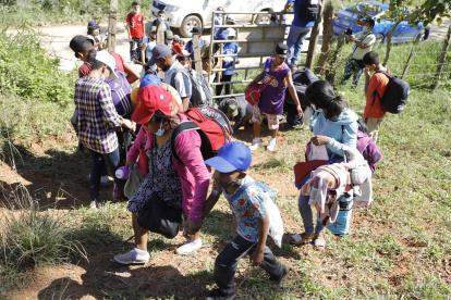 Un grupo de migrantes hondureños tratan de evitar los puntos de control migratorio recorriendo otros caminos en el Municipio de Omoa (Honduras), en una fotografía de archivo.