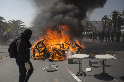 Manifestantes encienden, el 1 de mayo de 2022, una barricada durante una marcha con motivo del Día Internacional del Trabajo, en Santiago (Chile).