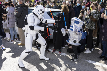 Un soldado de asalto imperial de la saga cinematográfica Star Wars se acerca a dos niños disfrazados mientras participan en el desfile del Galaxy Day, el domingo por una calle de Madrid.