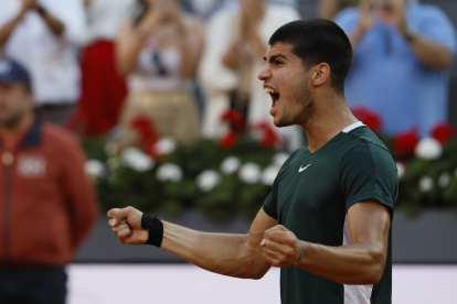 El tenista español Carlos Alcaraz celebra la victoria ante el serbio Novak Djokovic, tras el partido de semifinal del Mutua Madrid Open