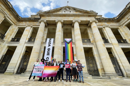 Integrantes de la comunidad LGBTI sostienen hoy carteles en la entrada del Congreso en Bogotá (Colombia).