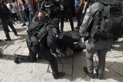 La policía israelí arresta a un hombre durante el cortejo fúnebre de la periodista Shireen Abu Akleh.