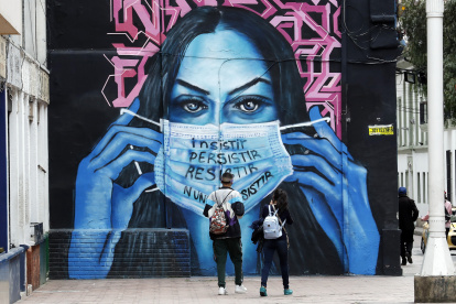 Un mural en Bogotá, donde una mujer sostiene una mascarilla, hace referencia a la terrible pandemia de la COVID-19 en el mundo.