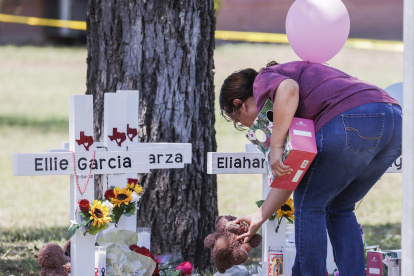 Una mujer coloca un animal de peluche junto a una cruz con el nombre de una víctima luego de un tiroteo masivo en la Escuela Primaria Robb en Uvalde, Texas, EE. UU., el 26 de mayo de 2022.
