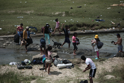 Un grupo de venezolanos atraviesan un riachuelo en la frontera entre Ecuador y Perú.