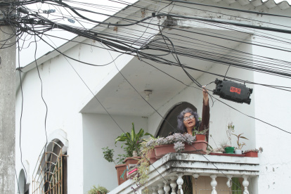 Marisol Paredes, quien reside en la manzana 207 de Guayacanes, muestra a EXPRESO la hilera de cables que cruzan el balcón de  su casa. Muchos de ellos no tienen ninguna función, pero nadie los ha ido a retirar.