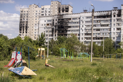 Juegos infantiles frente edificios dañados por bombardeos rusos en Járkov