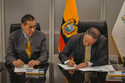 Francisco Cepeda, presidente del Consejo Directivo del IESS, y el ministro de Finanzas, Simón Cueva, durante el pago de parte de la deuda por salud.