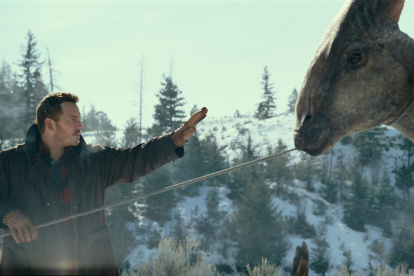 El actor Chris Pratt, en el papel de Owen Grady, se acerca a un parasaurolophus en una escena de la película Jurassic World Dominion.