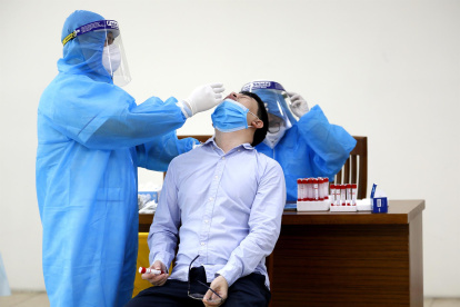 Un sanitario realizando una prueba PCR en Hanói