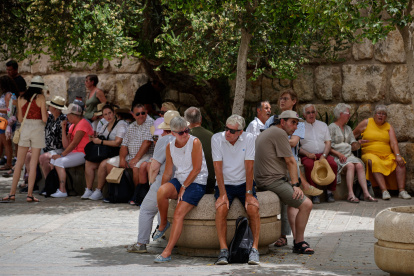 SEVILLA, 14/06/2022.- Unos turistas descansan sentados a la sombra junto a los Reales Alcázares de Sevilla hoy martes bajo la intensa ola de calor que mantiene en alerta a toda España, salvo Asturias y Canarias, con temperaturas extremas que dispararán los termómetros hasta los 43-44 grados en zonas del valle del Guadalquivir . EFE/Julio Muñoz