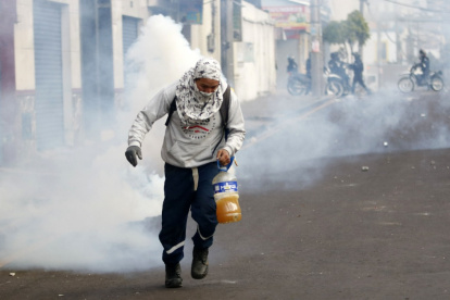 Protestas. Manifestantes portando elementos explosivos durante la protesta de este martes.
