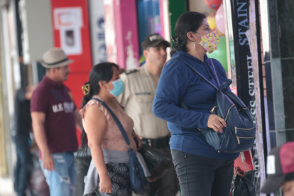 Seguridad. En el sector de la Bahía, en el centro de Guayaquil, compradores cuidan sus pertenencias.