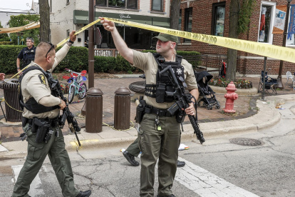 Un par de agentes policiales fue registrado este lunes al inspeccionar la escena de un tiroteo masivo, durante un desfile del 4 de julio, en Highland Park (Illinois, EE.UU.).