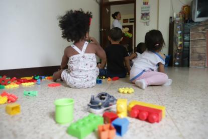 Infancia. Pequeños permanecen en un salón de juegos de una institución a cargo de su cuidado. Una de las tutoras los vigila desde uno de los accesos.