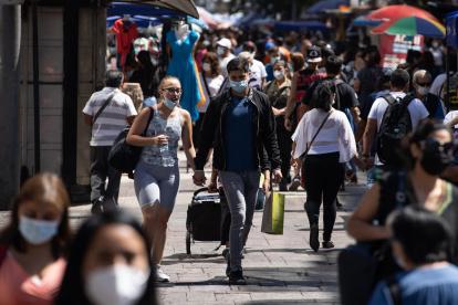 Un hombre carga una bolsa de comercio por una calle del centro de Santiago (Chile)