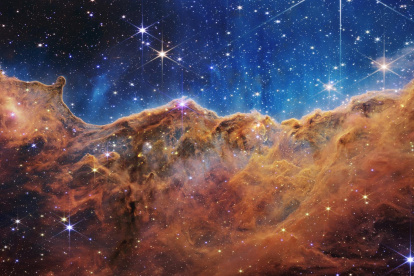 magen del borde de una región cercana y joven donde se forman estrellas, llamada NGC 3324, en la Nebulosa de Carina, que se asemeja a un paisaje de "montañas" y "valles" salpicados de estrellas brillantes.