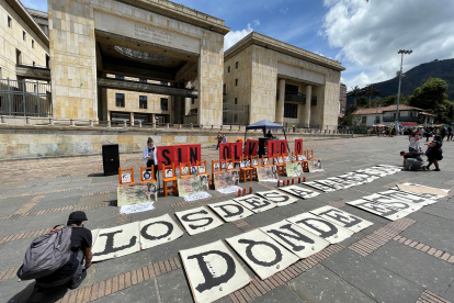 Familiares de las víctimas de desaparición forzada conmemoran con una exhibición de fotografías que conforman la Galería de la Memoria de la toma del Palacio de Justicia, en la Plaza de Bolívar de Bogotá (Colombia).