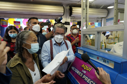 El ministro José Ruales acompaña a la usuaria Bélgica Vera a retirar sus medicinas en una farmacia.