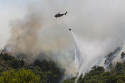Un helicóptero de extinción vierte agua en el incendio forestal iniciado en la sierra de Mijas, Costa del Sol, sur de España.