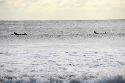 Surfistas en la plata de Rockaway, New York