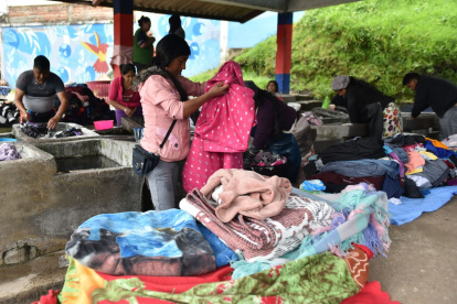 Las mujeres clasifican la ropa por el tipo de tela y color para lavarla por separado.