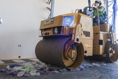Una máquina aplanadora pasa por encima de decenas de botellas de plástico para iniciar el proceso de reciclado, el 22 de julio de 2022, en Galápagos (Ecuador).