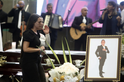 Daniela Alzate Gómez nieta del fallecido cantante colombiano Darío Gómez "El rey del despecho", camina frente al féretro de su abuelo durante un homenaje hoy en el coliseo Yesid Santos en Medellín (Colombia).