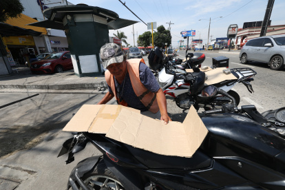 Motos. En días con sol, Freddy Mazón recurre a cartones para colocar sobre los asientos de las motos que cuida. Así se gana más ‘voluntad’ de quienes confían en su labor.