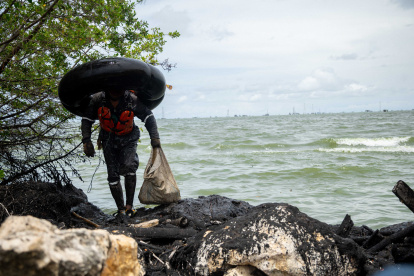 Un hombre se gana la vida entre restos petroleros sobre la costa oriental del Lago de Maracaibo.EFE- HENRY CHIRINOS