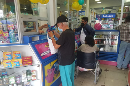 Segundo Luna, de 70 años, retira su insulina en la farmacia ubicada frente al Hospital Abel Gilbert, en el suroeste de la ciudad. Al fondo, un familiar hace lo mismo con los fármacos de un persona con movilidad reducida.