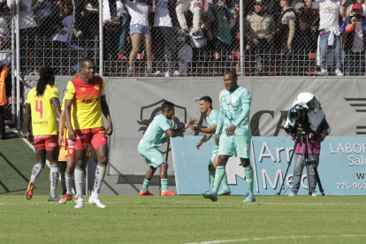 Danny Luna festeja el tanto albo con Alexander Alvarado, mientras los jugadores de Aucas se lamentan.