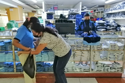 Tienda.- Madre de familia compra ropa para su hija.