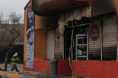 Bomberos trabajan en una tienda que fue incendiada por personas armadas hoy en Ciudad Juárez, estado de Chihuahua (México). EFE/Luis Torres