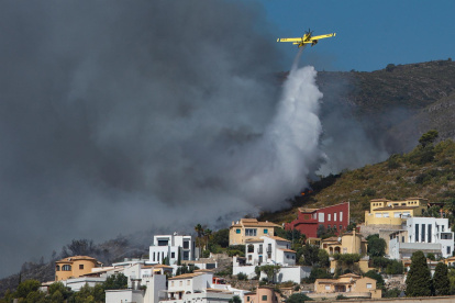 Una avioneta descarga agua sobre el fuego originado en Vall d"Ebo, provincia española de Alicante.