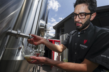 El gerente de producción de Sinners Micro Cervecería, Andrés Bermeo, sirve una muestra de la cerveza el 19 de agosto de 2022 en Quito (Ecuador).