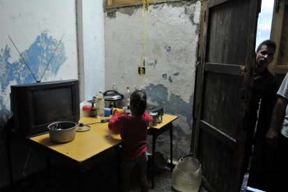 Fotografía de archivo fechada el 10 de septiembre de 2008 que muestra a una niña mientras lava platos en una improvisada cocina en el poblado José Martí, municipio de San Cristóbal, provincia de Pinar del Río (Cuba).