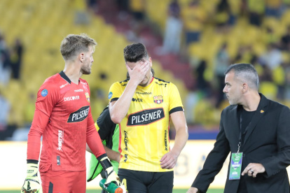 Javier Burrai intenta consolar al defensor amarillo, Paco Rodríguez, quien marcó el gol de Barcelona, pero influyó en el empate final de Liga de Quito.