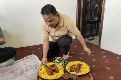 Un residente en Qatar sirve la comida en el piso, como es una de las costumbres en el lugar.